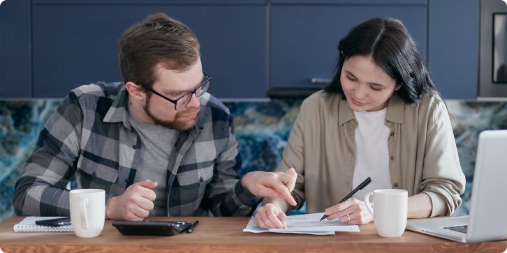 Two homeowners reviewing options on a sheet of paper