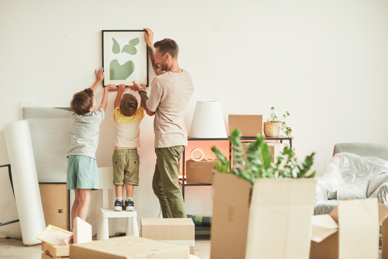 Father and sons hanging a picture on the wall