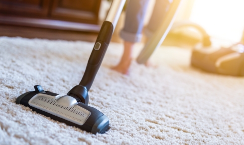vacuum cleaner cleaning a carpet in a bright home