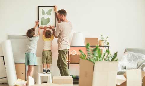 Father and sons hanging a picture on the wall